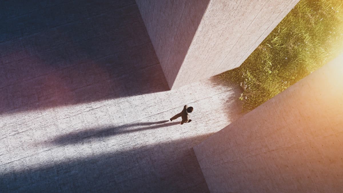 man walking to open gate into a green world 