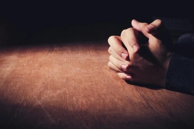 clasped hands on a table/praying hands