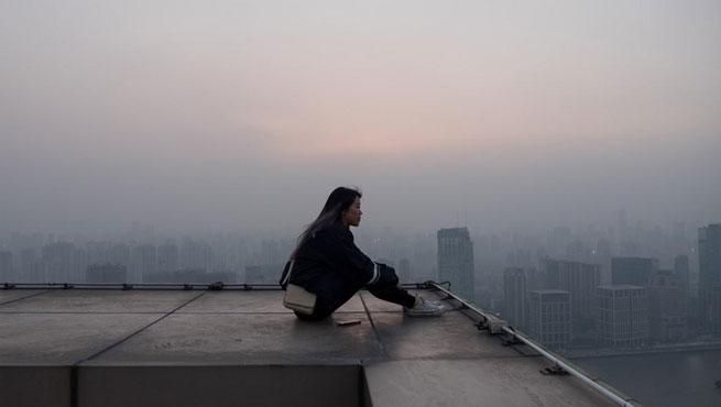 girl city on roof with foggy city scape behind her